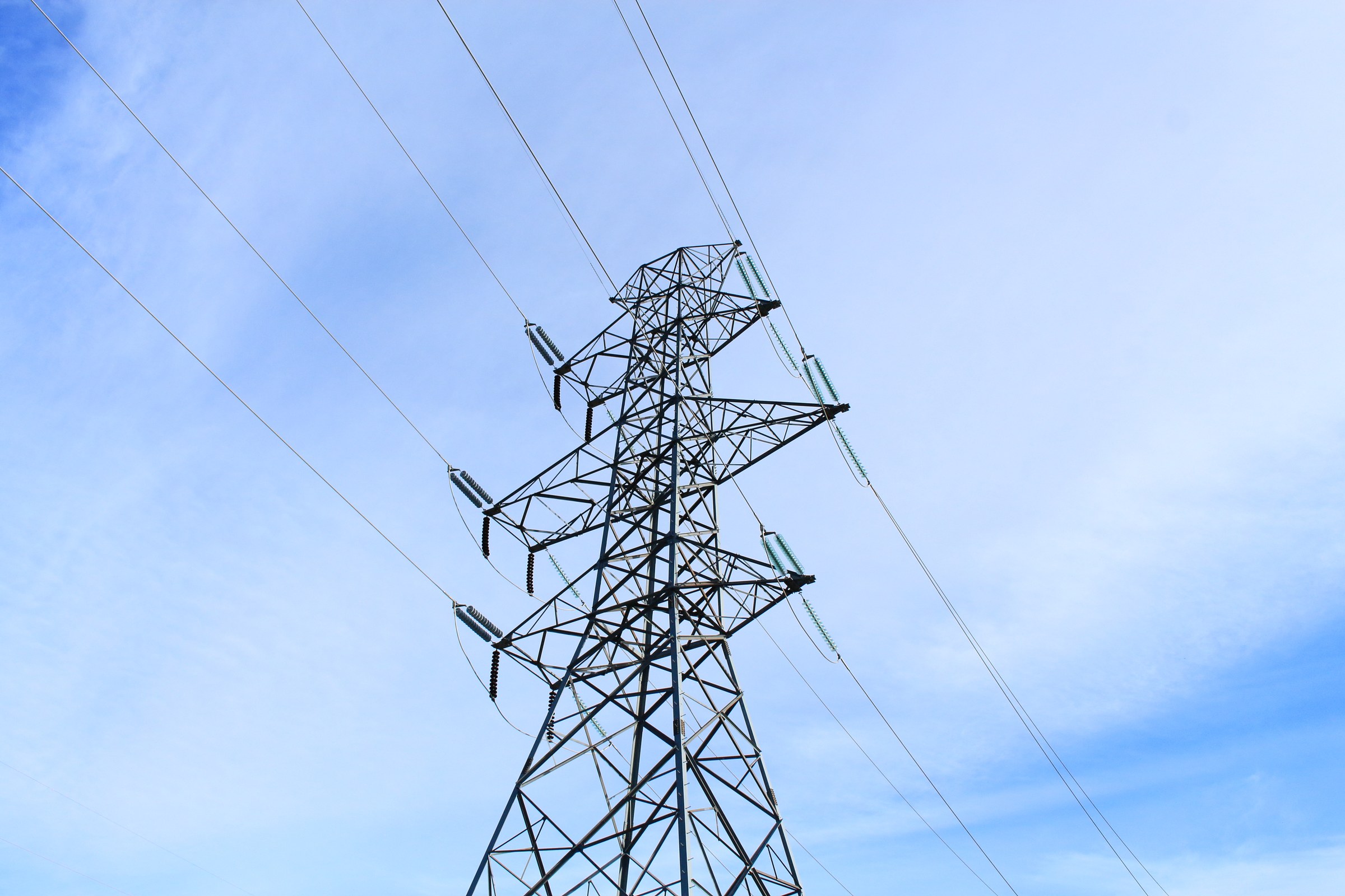 A high-voltage transmission tower against open sky near Lethbridge, Alberta