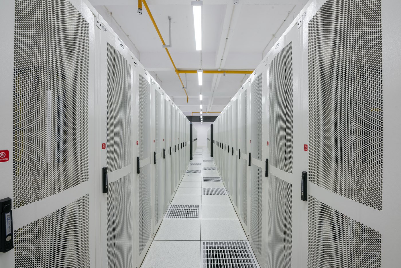 A cold aisle between locked server cabinets in a data centre